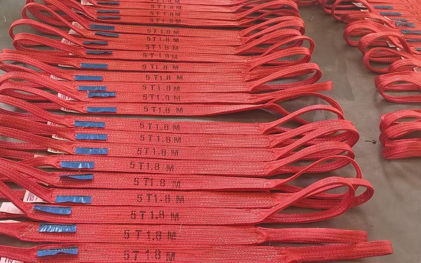 红色 5T × 1.8M 双扣扁平吊装带逐根检验阵列,可见吨位标识与蓝色合格证标